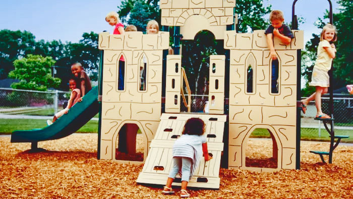 Kids playing on a playground shaped like a castle