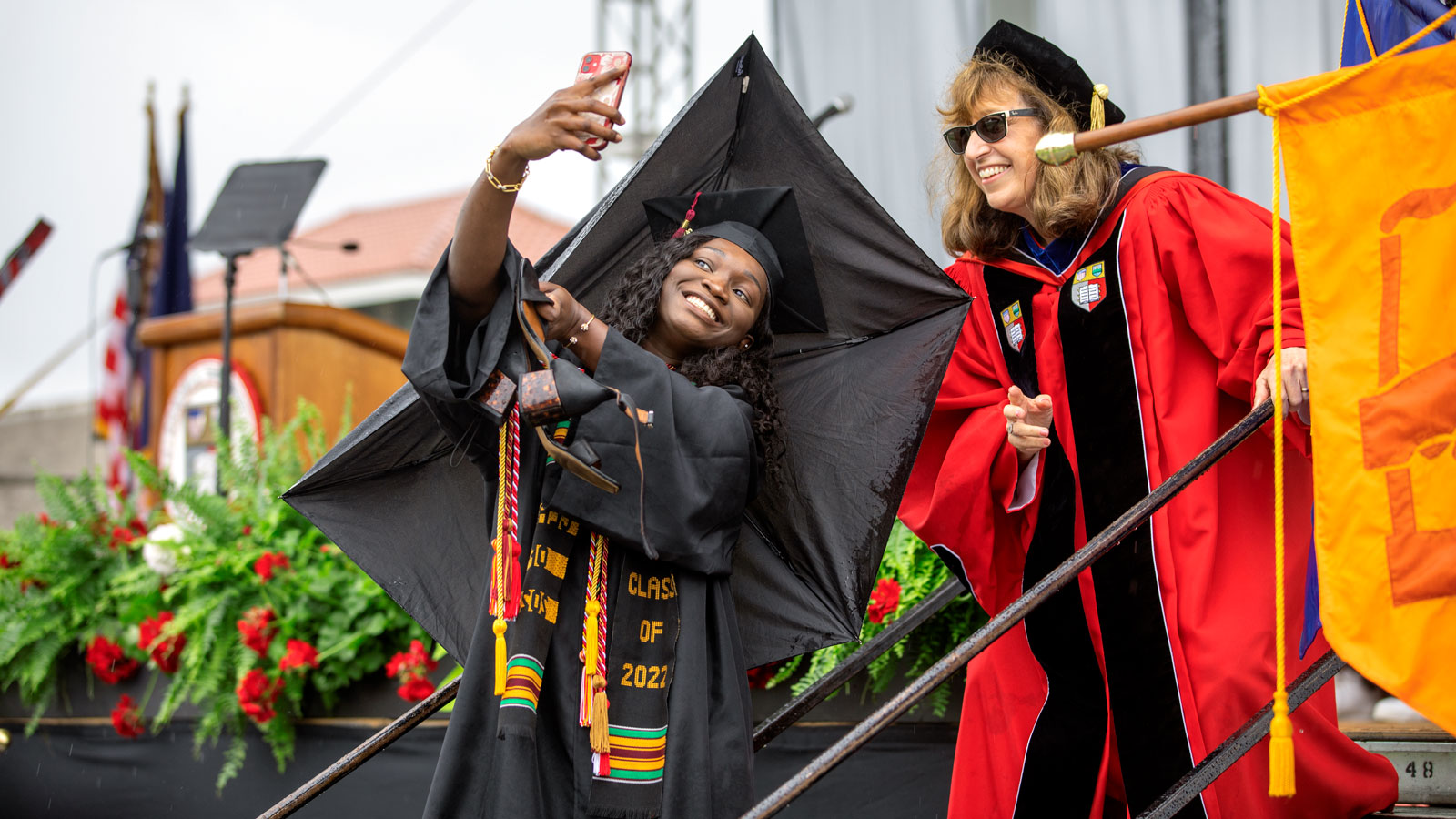 President Martha Pollack poses for a selfie with a graduating senior during Commencement 2022