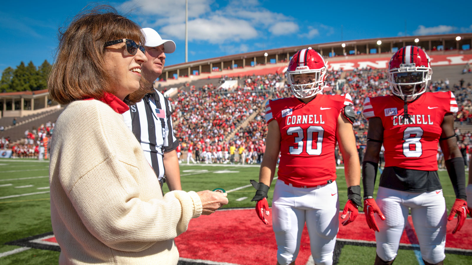 President Martha Pollack prepares for the coin toss at a Big Red football game in Schoellkopf in 2022