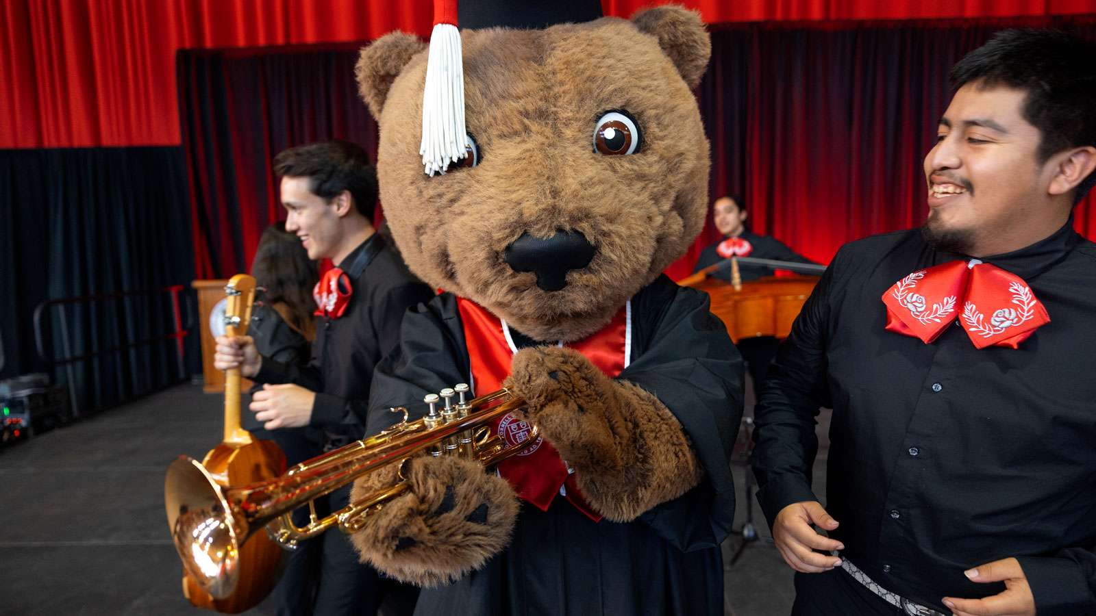 Touchdown the Bear, decked out in mortarboard and tassel and holding a trumpet, enjoys Senior Convocation events as part of Commencement 2024