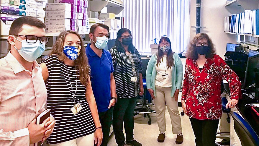 Martha Pollack wearing a mask visiting Cornell's COVID testing lab