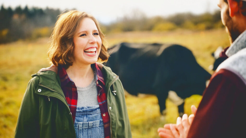 Vanessa Bayer at Beck Farms with a cow behind her.