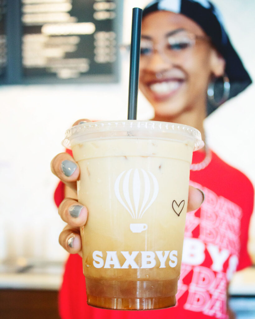 A Saxbys barista holds up an iced coffee.
