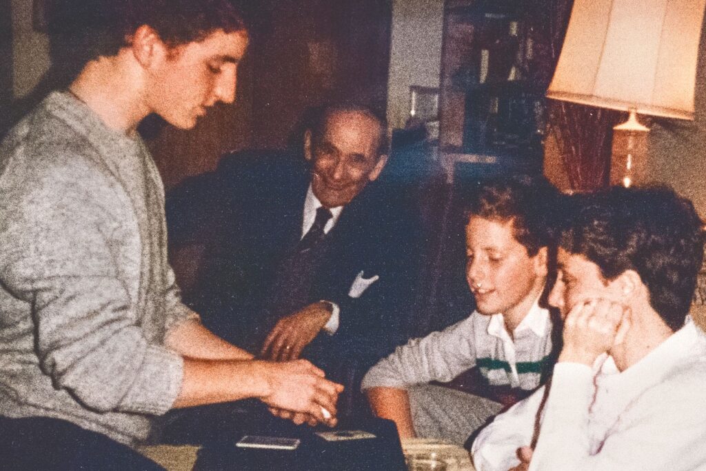 A 14-year-old Steve Cohen does card tricks at a family party as his great uncle, Nat Zuckerman, looks on
