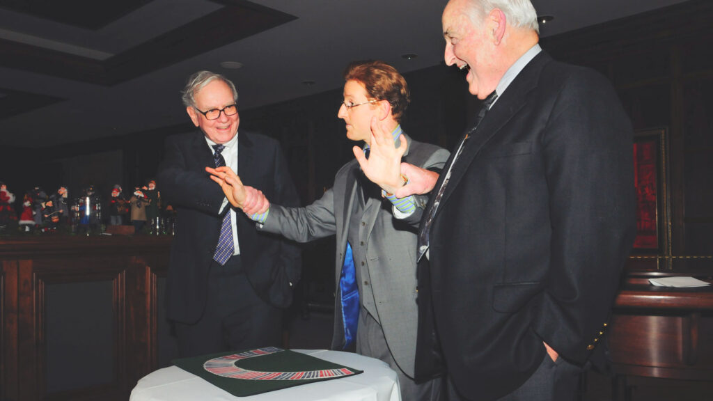 Steve Cohen performs a trick for Warren Buffett, left, and Walter Scott at a private party in Omaha, Nebraska