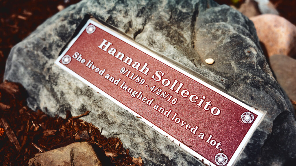 The memorial for Hannah Sollecito with a plaque that says "She lived and laughed and loved a lot."