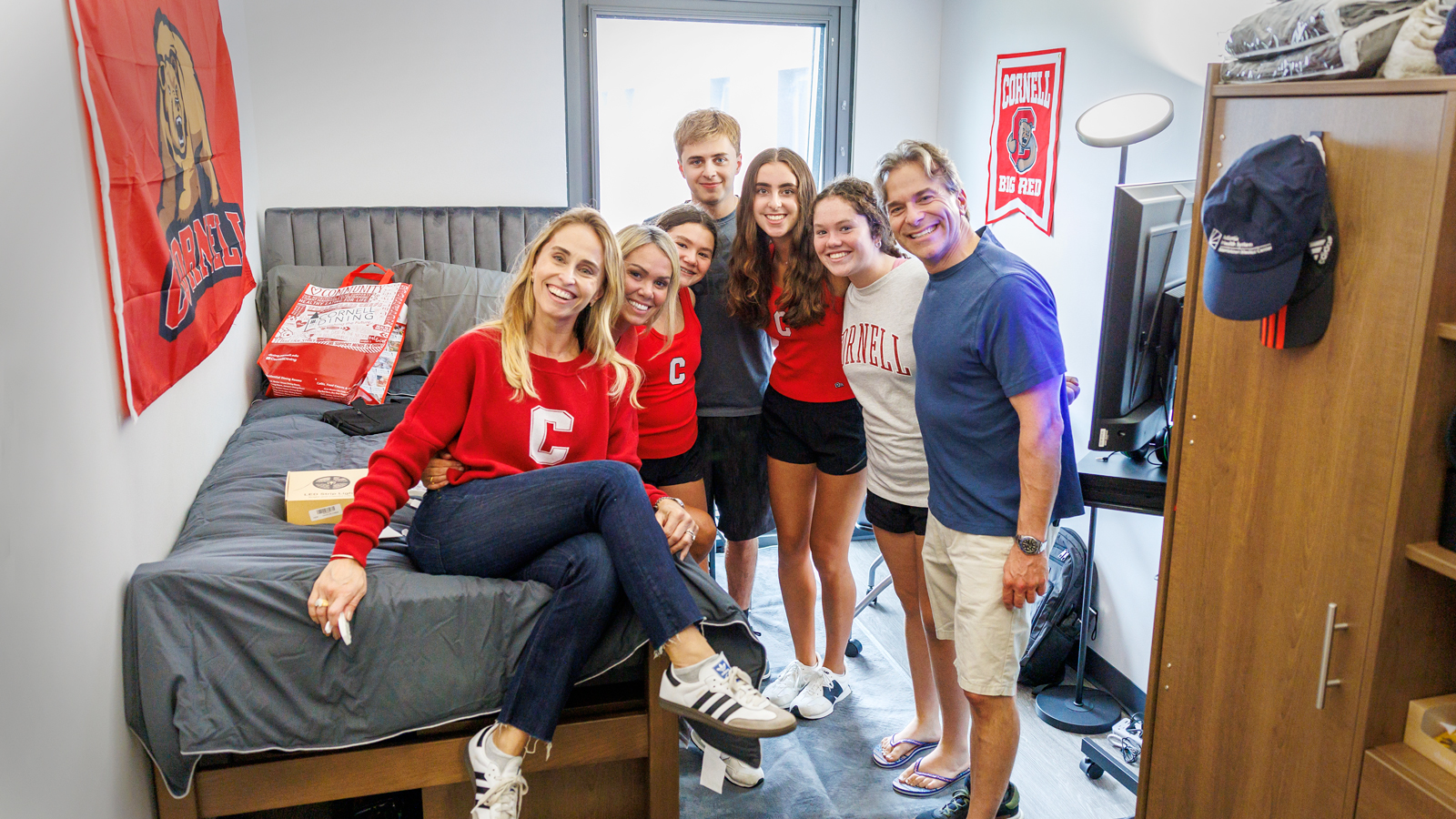 A Cornellian family poses for a group photo at Ruth Bader Ginsburg Hall during Move-In 2024 on North Campus