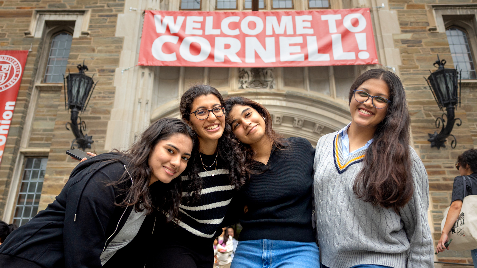 Students and family members pose in front of Willard Straight Hall during Move-In 2024