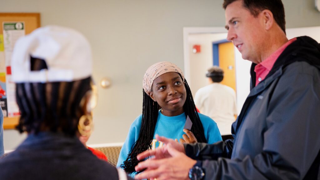 Students chat with Ryan Lombardi, vice president for student and campus life, during the Big Red Welcome Party for new Cornell families at Willard Straight Hall during Move-In 2024