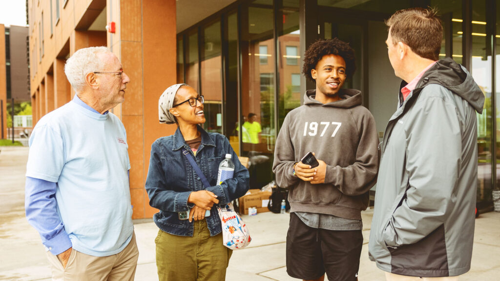 Mike Kotlikoff and Ryan Lombardi talk to a mother and son during Move-In