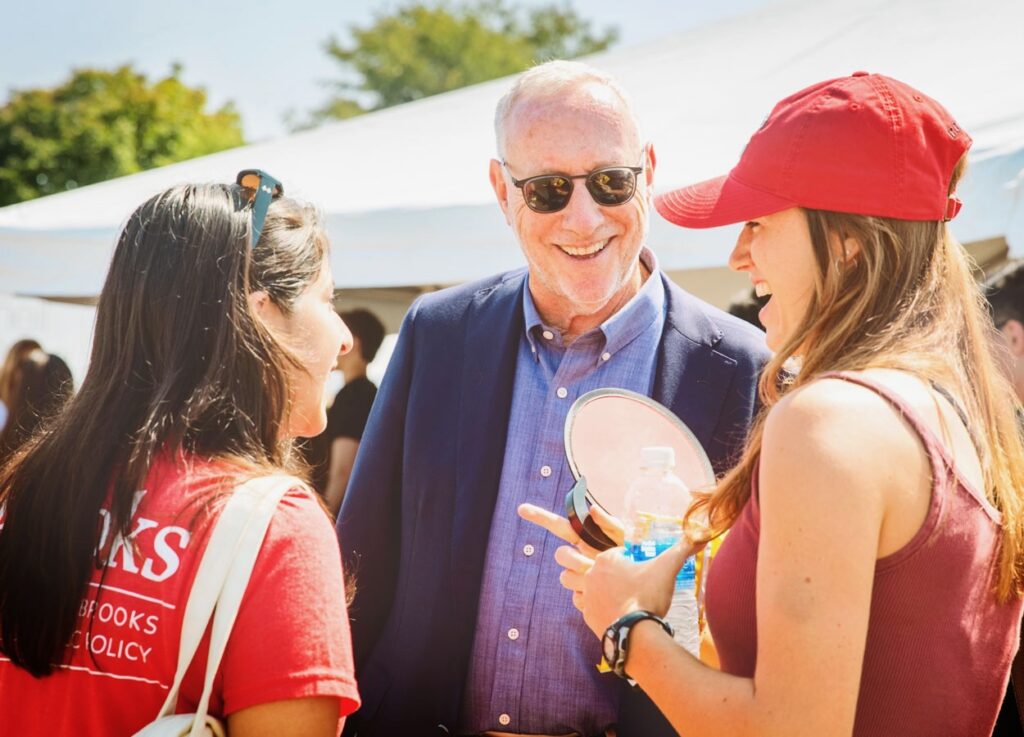 Mike Kotlikoff chats with two female students outside a white tent