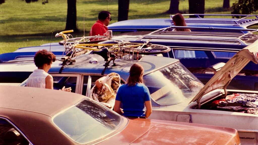 A bicycle is stashed atop a car in a campus Move-In scene from 1972