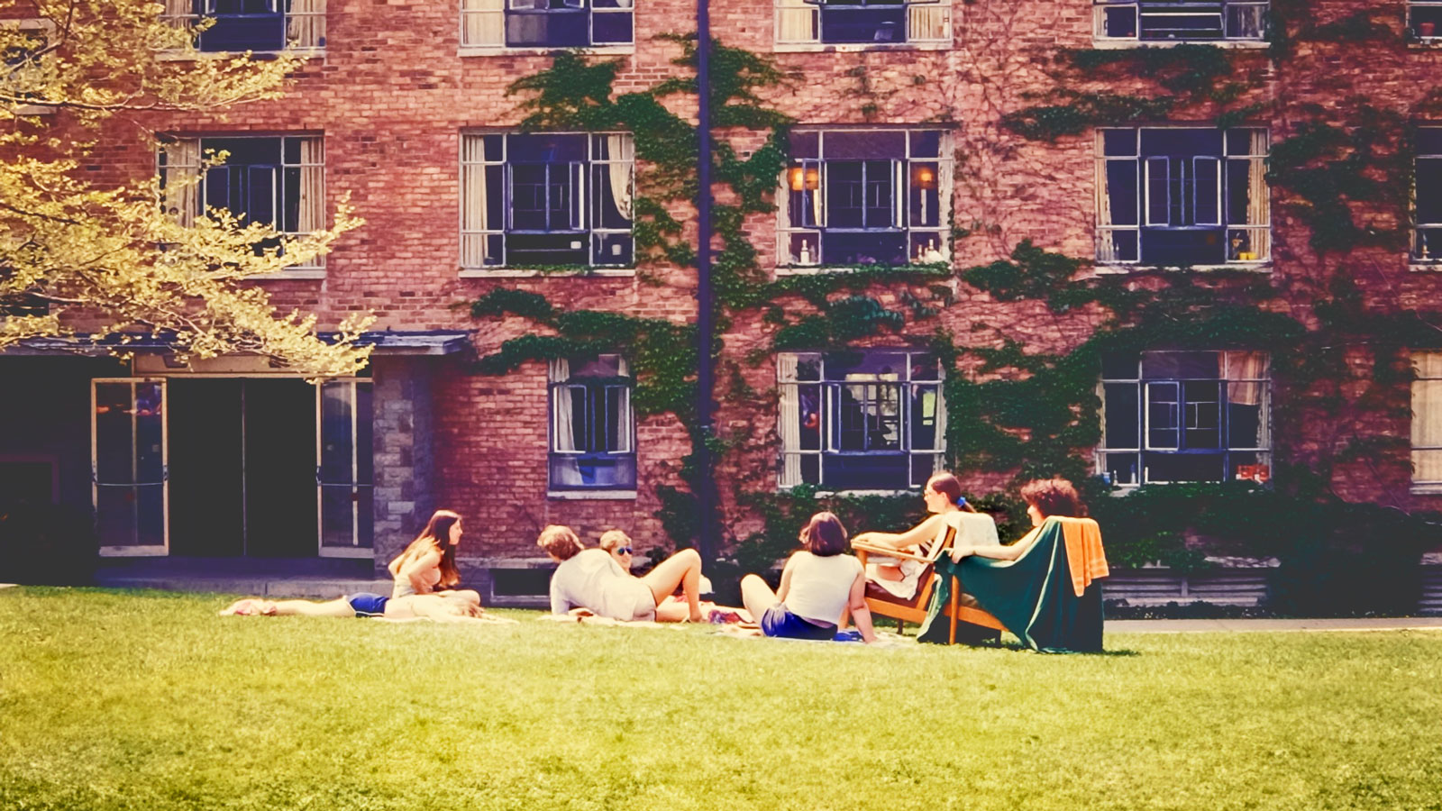 View of students lounging on a lawn outside one of the University Halls, 1979