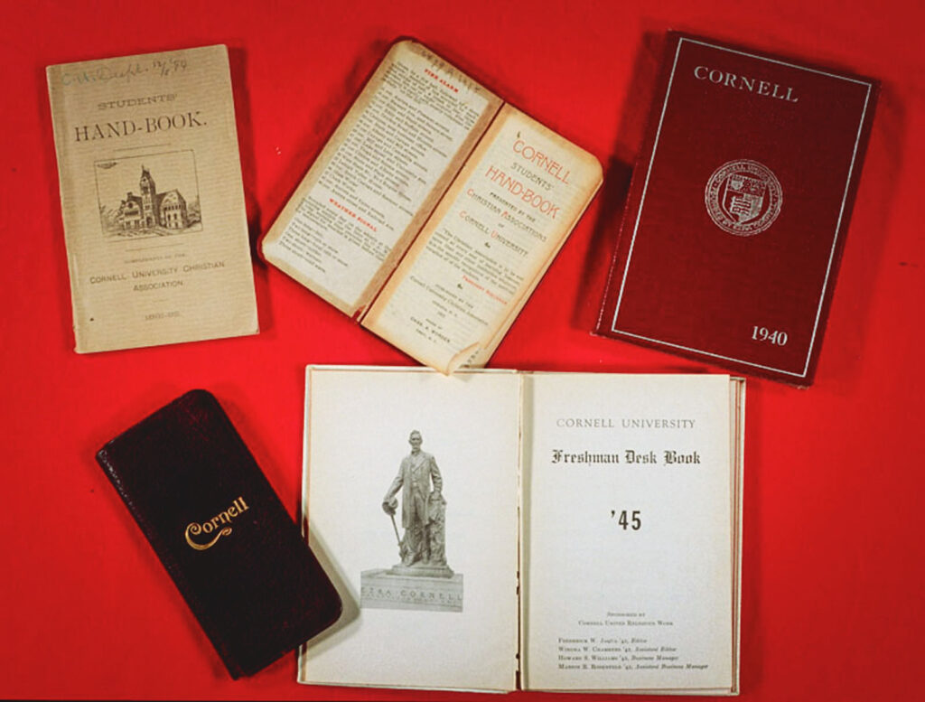 Five vintage editions of the Cornell new student handbook on a red background