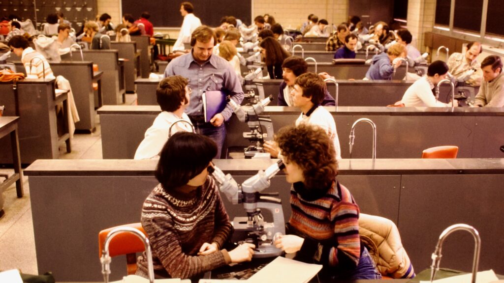 Students in a lab look into microscopes at the College of Veterinary Medicine, 1981