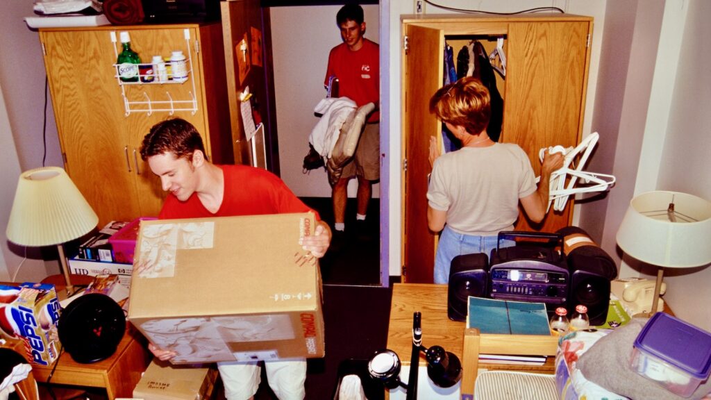 Volunteers help students move into a residence hall room in the 1990s