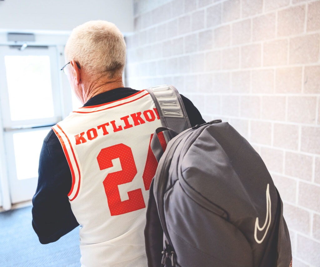 Interim President Mike Kotlikoff, sporting a jersey with his name, prepares to exit Bartels Hall after meeting with student athletes and athletics staff in 2024