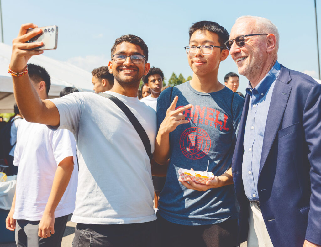 Interim President Mike Kotlikoff poses for a selfie with students during New Student Convocation in 2024