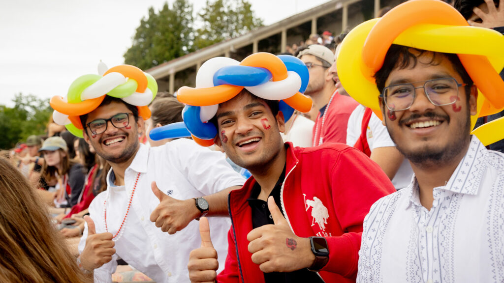 fans, wearing balloon hats, pose for a photo at Schoellkopf Stadium during Homecoming 2024