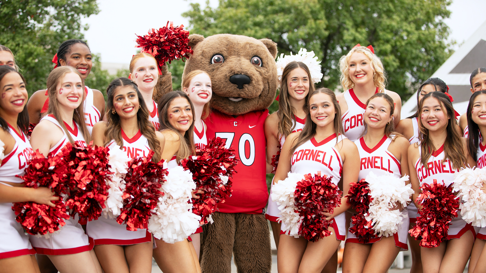 Touchdown, the unofficial mascot of the Cornell Big Red, poses with the Cornell Cheerleading squad at Homecoming 2024