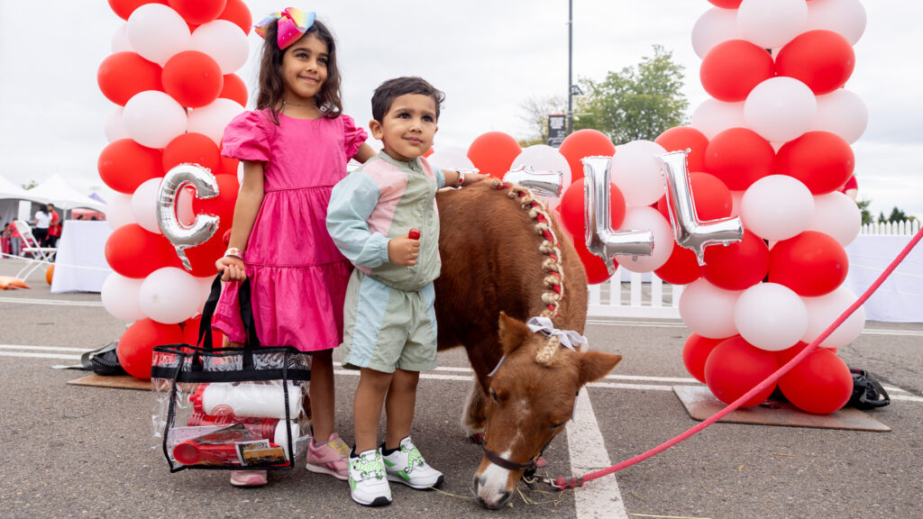 two young fans meet Minnie the miniature horse at the Big Red Fan Festival during Homecoming 2024