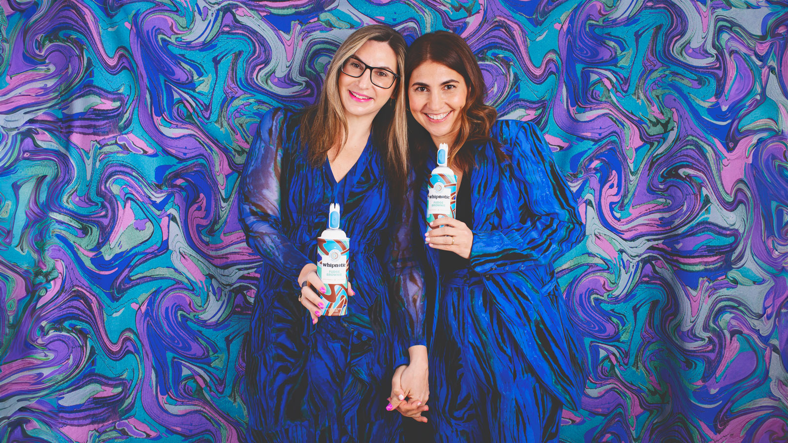 Lori Luckow Gitomer and Tracy Luckow pose with cans of Whipnotic whipped cream.