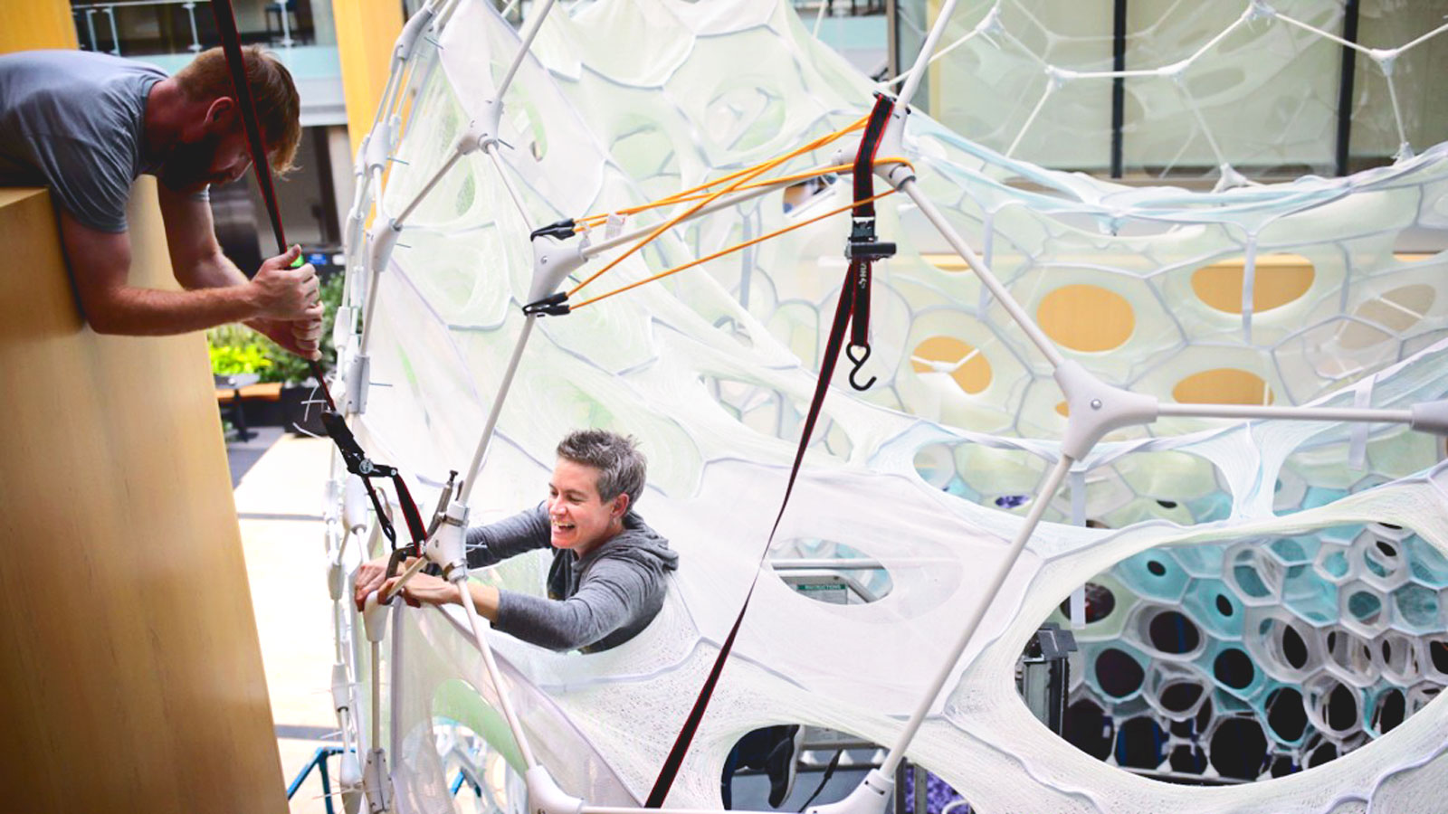 Jenny Sabin attaches a porous fabric quilt on to the exoskeleton of Ada, a responsive and photoluminescence fiber pavilion, at Microsoft Research in Redmond, Washington, in 2019