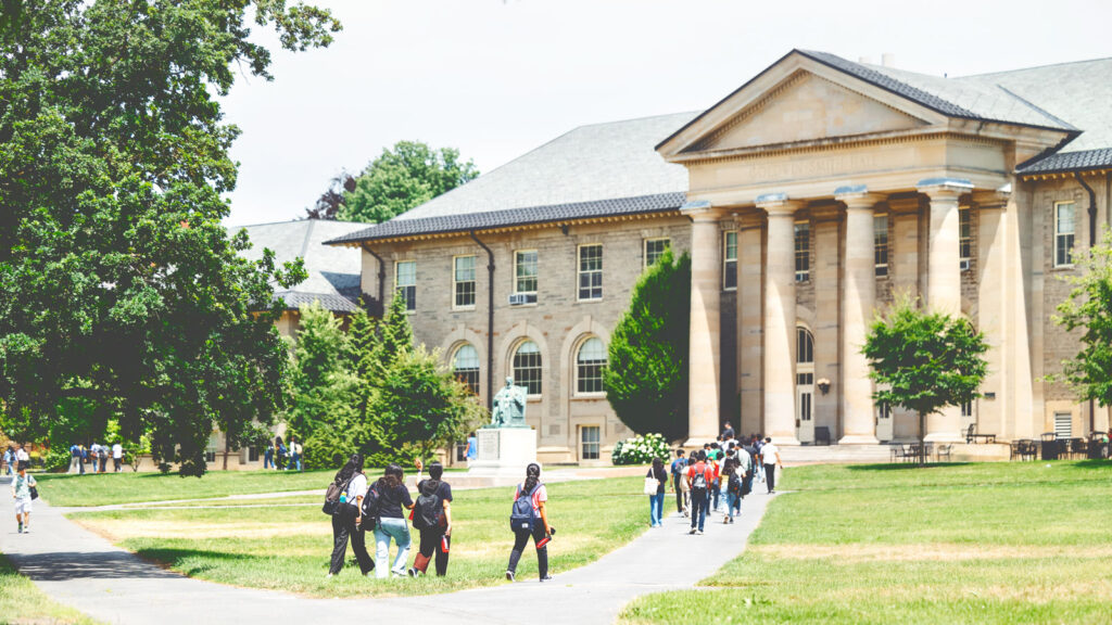 Summer student tours make their way through the Arts Quad towards Goldwin Smith Hall.