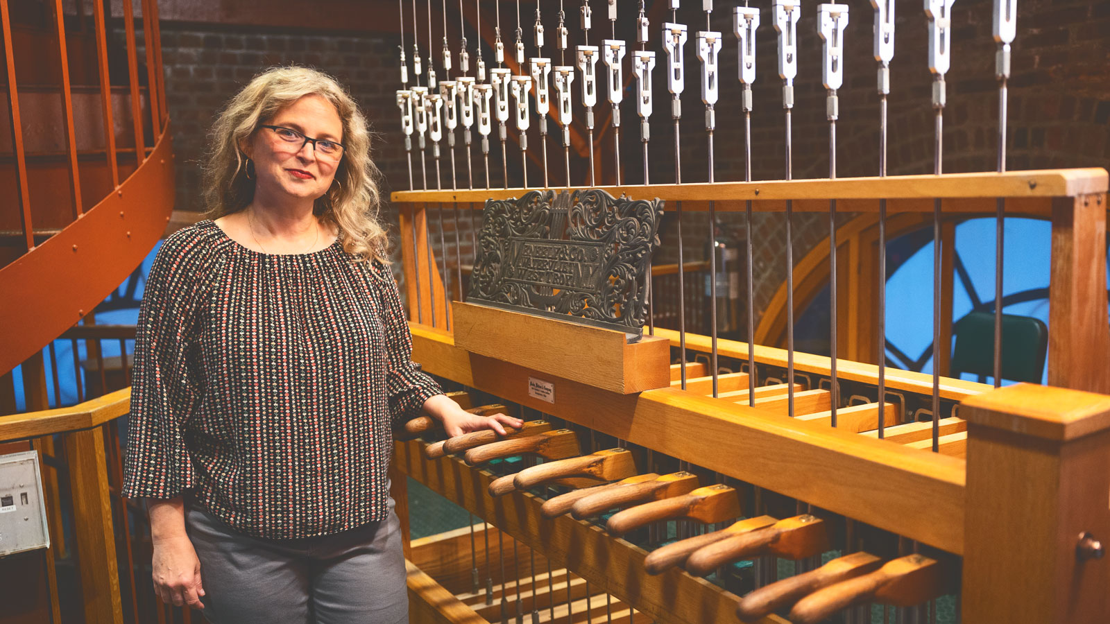 Chimes advisor Jennifer Lory-Moran next to the chimes in McGraw Tower.