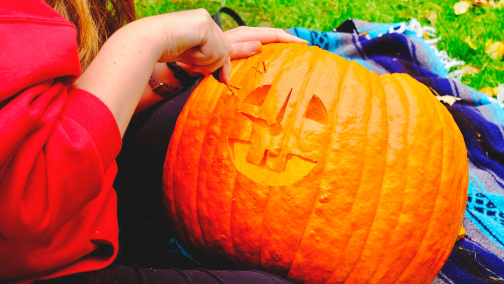 a pumpkin in the process of being carved with one of the Cornell-themed designs