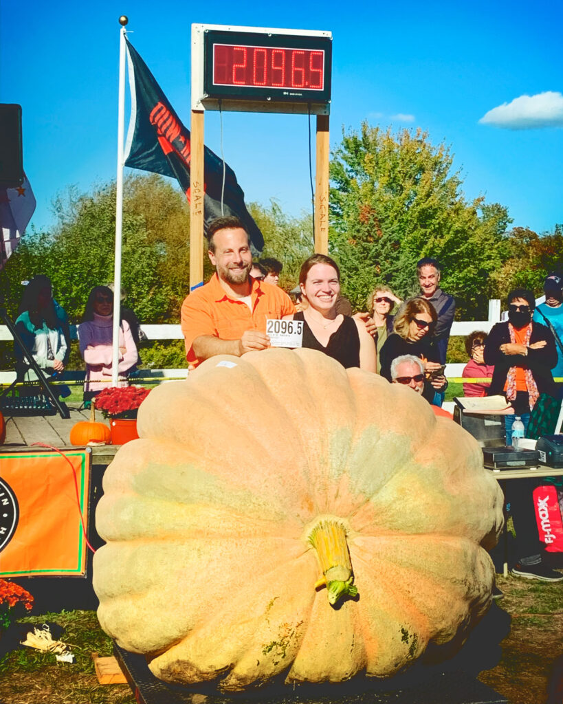 Alex Noel and his wife with a giant pumpkin weighing 2,096.5 pounds.