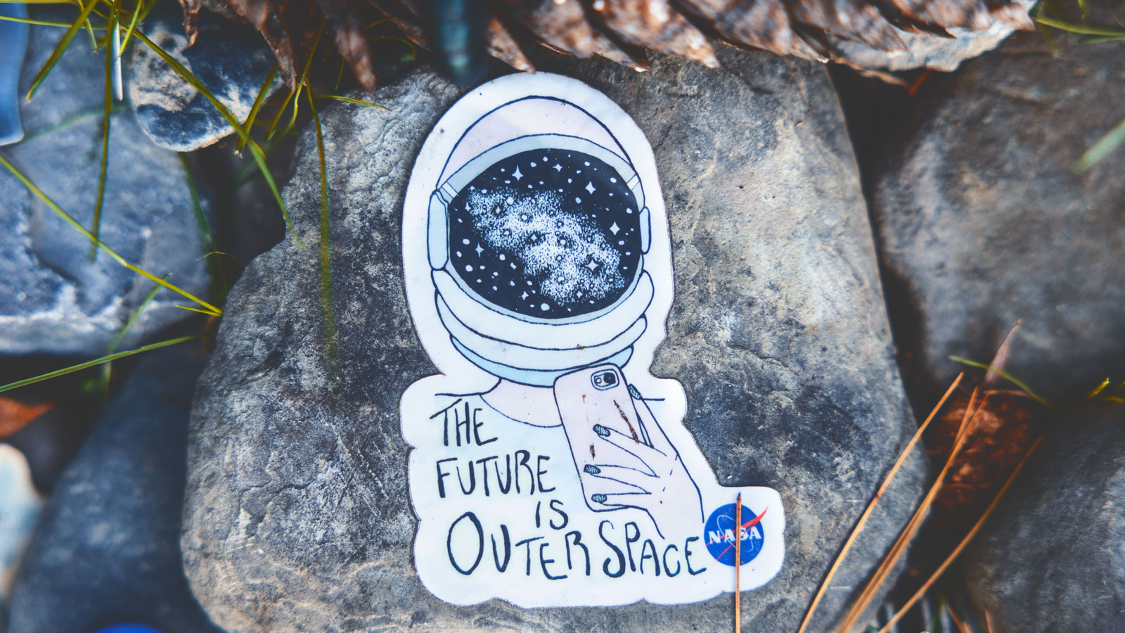 a sticker of an astronaut that says "the future is outer space" near the grave of Carl Sagan