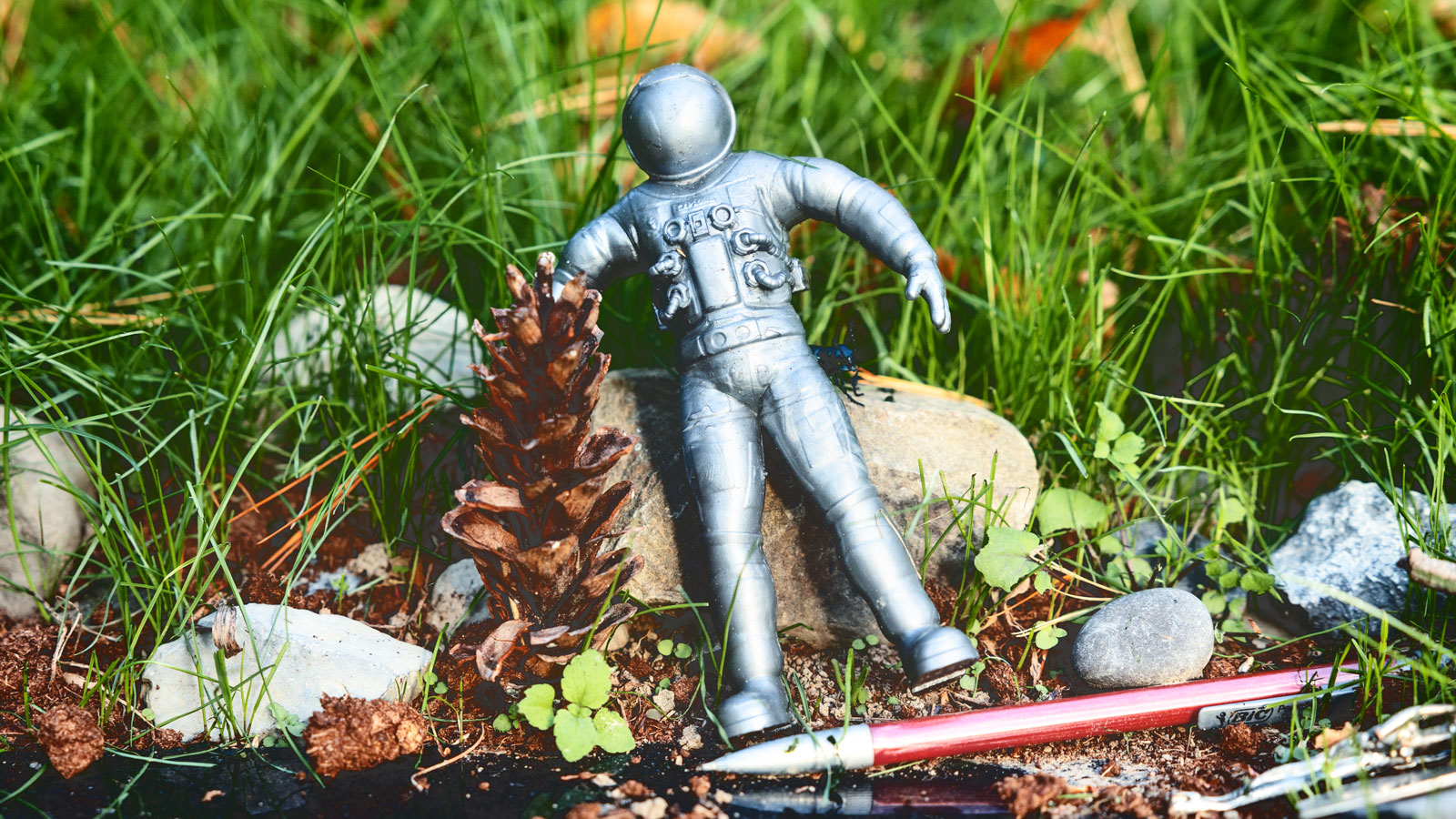 a toy spaceman and a pen near the grave of Carl Sagan