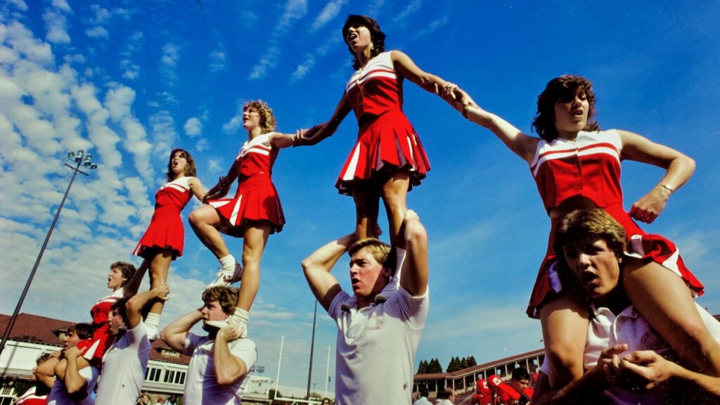 Big Red cheerleaders stand atop the shoulders of other students during a routine at Schoellkopf Stadium, 1984