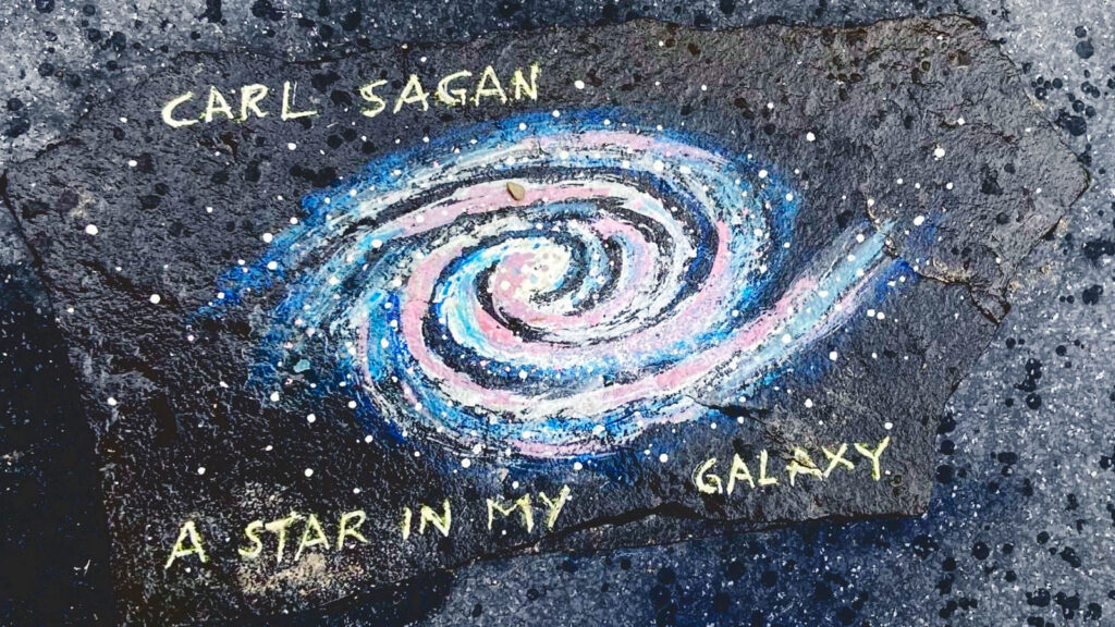 A chalk drawing of a spiral galaxy and the words "Carl Sagan / a star in my galaxy"