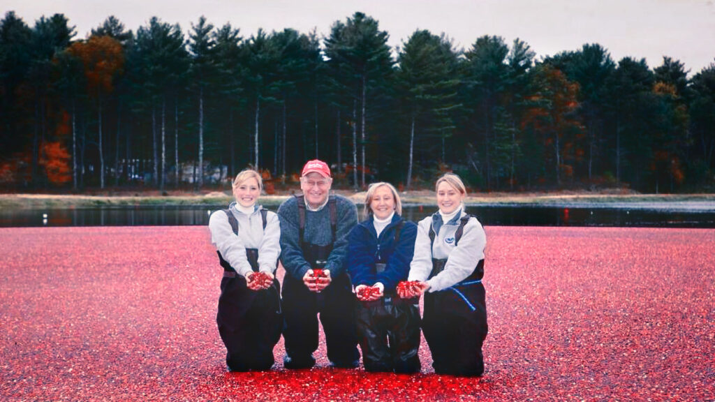 Sisters Alison Gilmore Carr and Abigail Gilmore Anderson with their parents in the cranberry bog during harvest season.