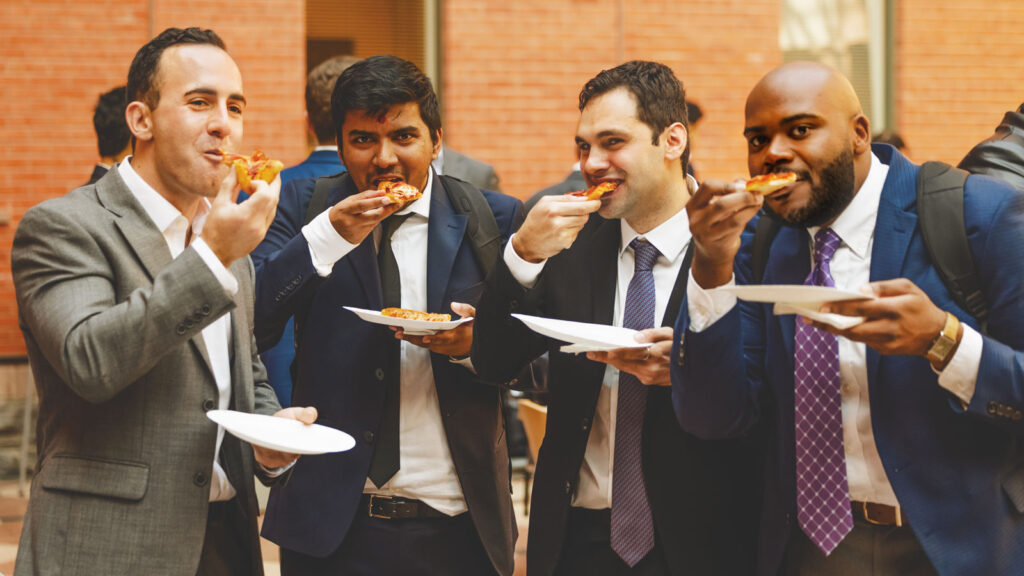 MBA students eating pizza in the Sage Hall atrium