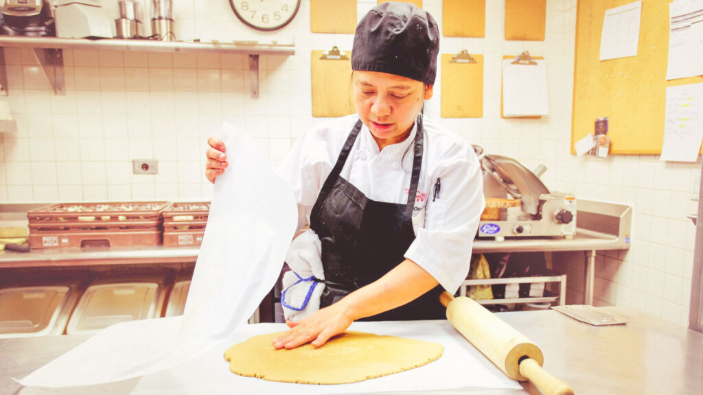 Haidee Bowles, line cook at the Cornell Club-NYC, checks the rolled-out gingerbread dough for the McGraw gingerbread tower project in the club kitchen