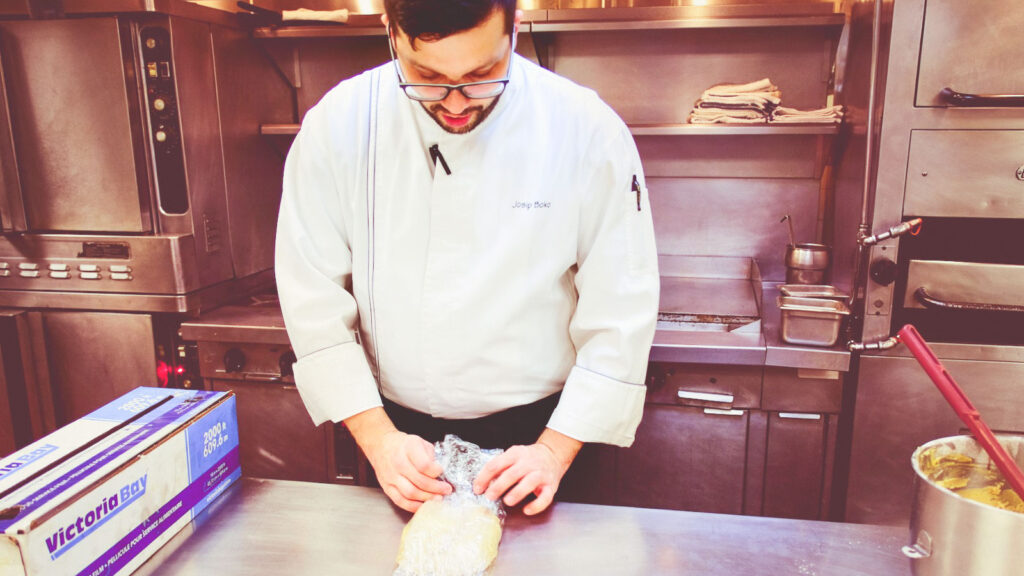 Joe Boko, executive chef at the Cornell Club-NYC, wraps some of the gingerbread batter in plastic wrap for cold proofing as part of prep for the gingerbread McGraw Tower project in the club kitchen