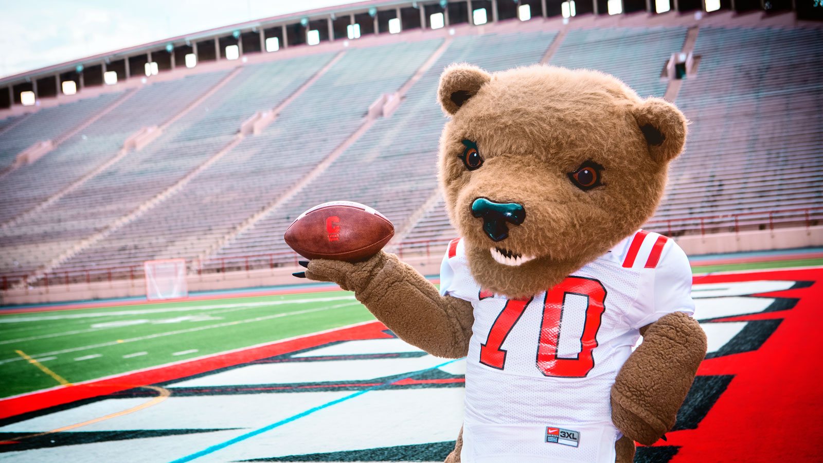 Touchdown the Bear holds a football in Schoellkopf