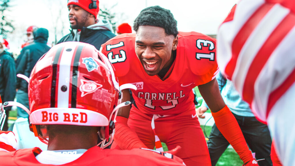 Jalyx Hunt smiles and high fives a player during a game.