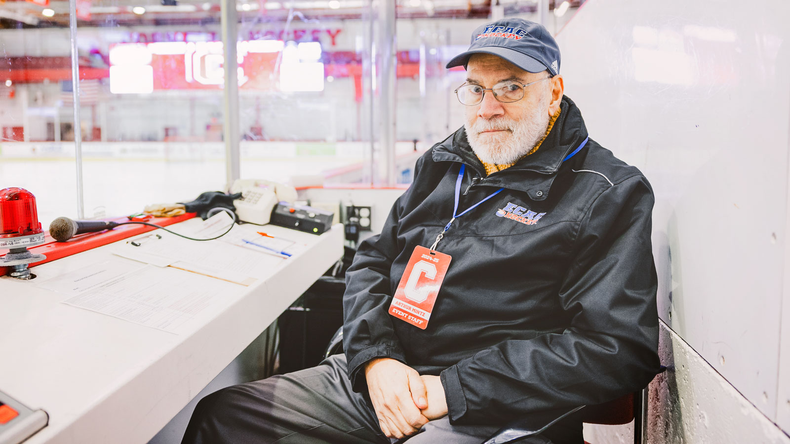 Arthur Mintz sits in the officials’ box before the Cornell vs. Harvard Men's Ice Hockey Game at Lynah Rink.