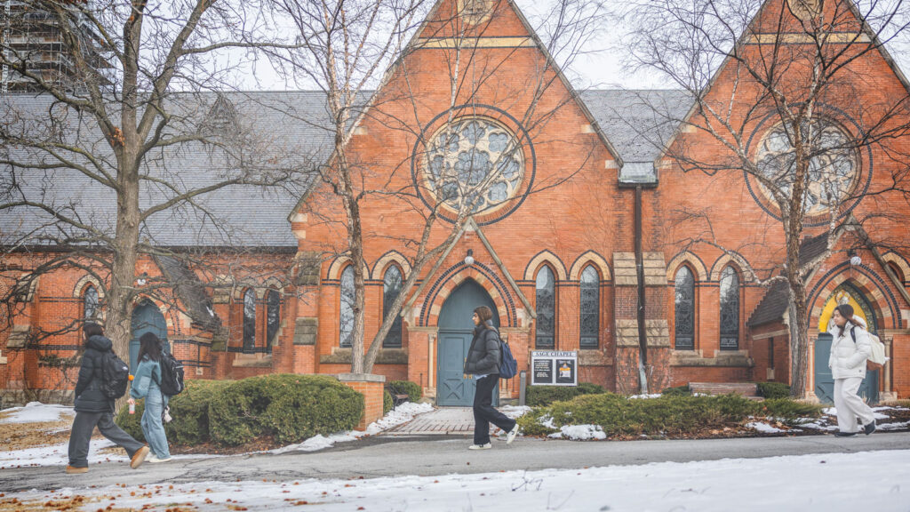 Students walk to class by Sage Chapel