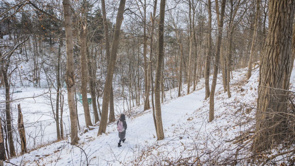 A student walks on the Cascadilla trail near the tennis courts