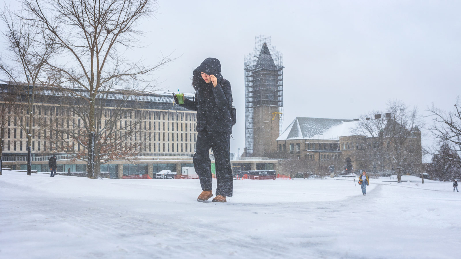 A student walks on the Arts Quad towards Goldwin Smith Hall during a snowstorm