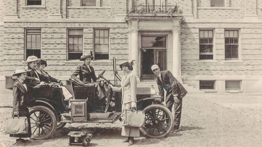 Martha Van Rensselaer is seated in the rear of an automobile, along with several home demonstration leaders and a student chauffeur, preparing for an extension trip in 1913