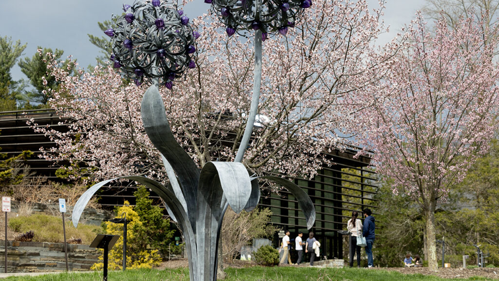A floral sculpture and flowering trees outside the Cornell Botanic Gardens welcome center