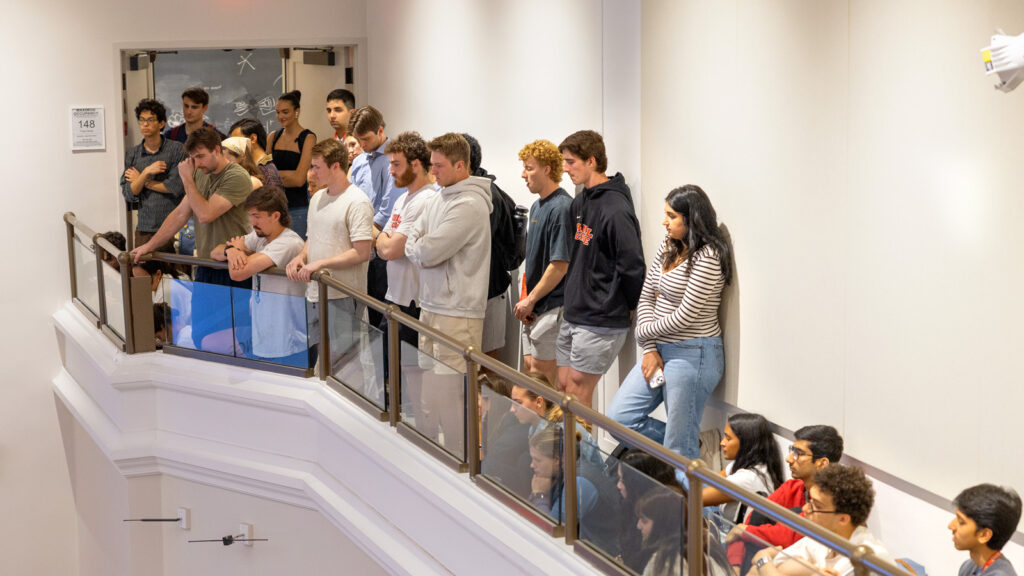 Students stand in a balcony as head Hockey Coach Mike Schafer speaks to a crowded auditorium in Baker Hall as his “Last Lecture” on Wednesday, April 23, 2025. (Ryan Young / Cornell University)