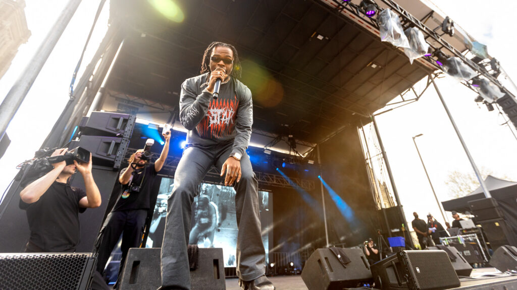 Slope Day rapper Gunna on stage holding a microphone to his mouth.