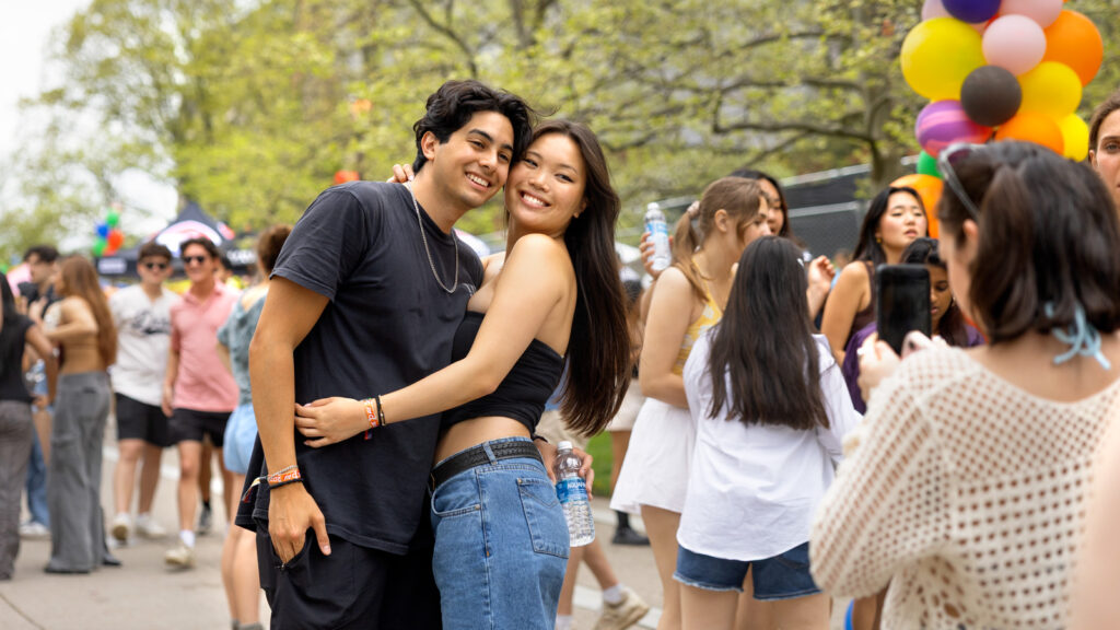 A girl and boy embrace each other and smile for a photo.